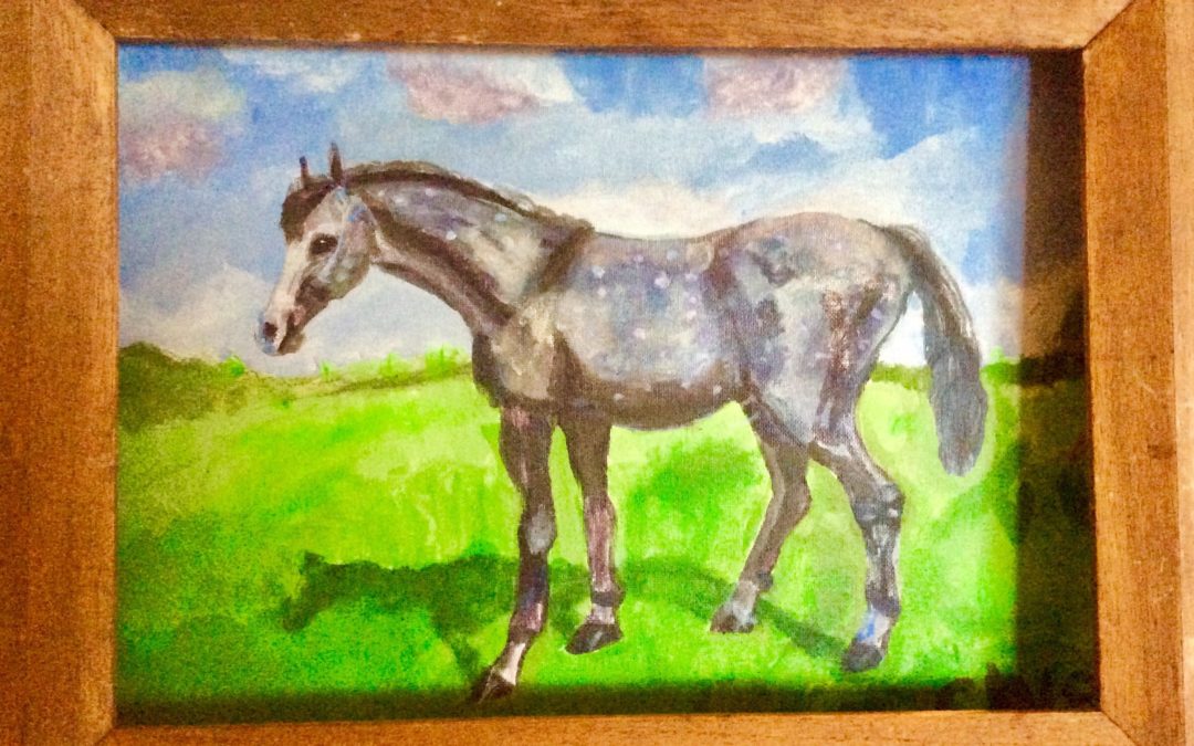A painted horse standing on green grass under a blue sky.